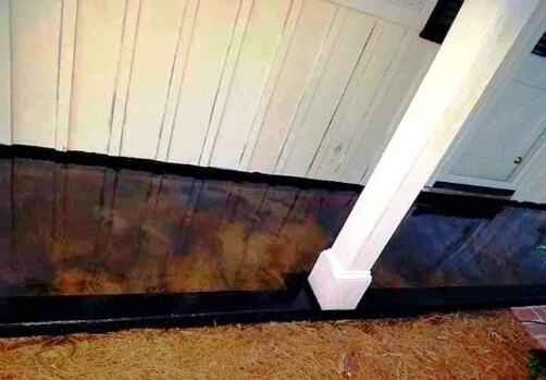 Stained concrete porch with two-toned brown stain and a contrasting dark border