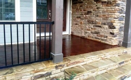 This Stained Concrete Porch Complements This Home's Stonework Exterior and Front Door